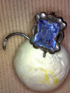 Stříbrná náušnice s modrým kamínkem.