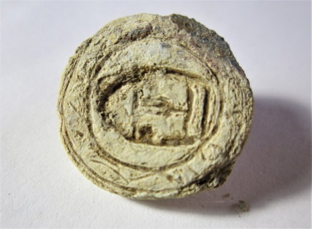 Archaicky vypadající zdobený knoflík