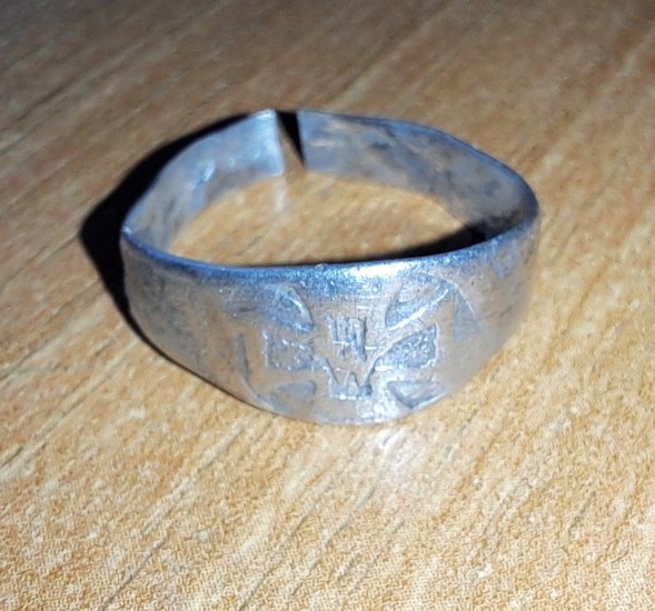 Prasklý stříbrný prsten s křížem a asi s W