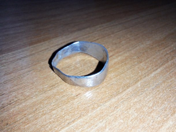 Prasklý stříbrný prsten s křížem a asi s W